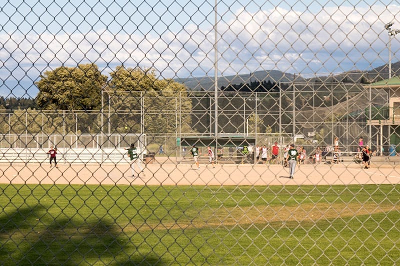 Kelowna Baseball at mission recreational park through a gate