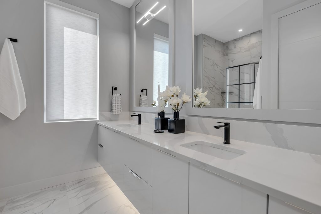 Penthouse primary ensuite with double vanity, shower, toilet closet, marble inspired tile and quartz countertops