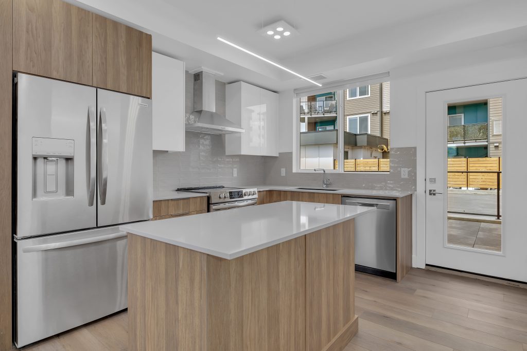 Green Square Vert 102C Townhome kitchen with two-tone cabinetry, quartz countertops and stainless appliances